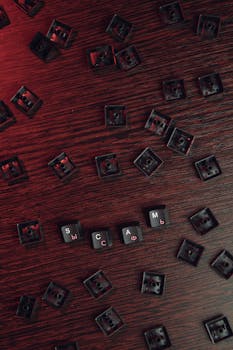 Aerial view of keyboard keys spelling 'SCAM' on a wooden surface, conveying digital deception.