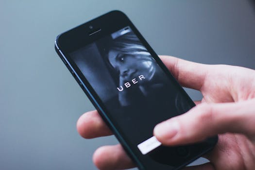 Close-up of a hand holding a smartphone with the Uber app open on the screen.