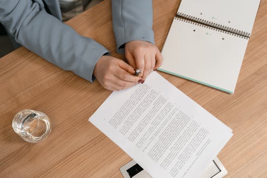 Hands reviewing documents on a wooden desk, ideal for business themes.