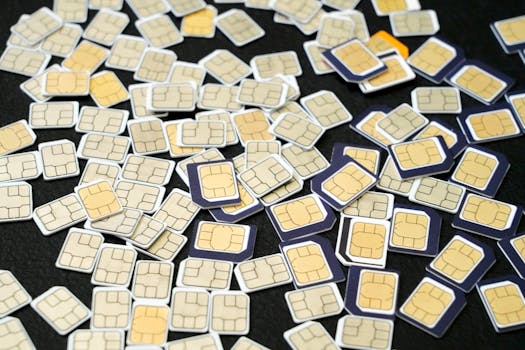 Multiple SIM cards scattered on a black surface, showcasing the complexity of cellular technology.