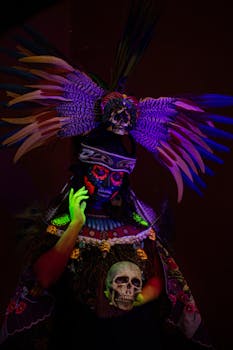 Colorful Día de los Muertos face paint with feathered headdress and skull.